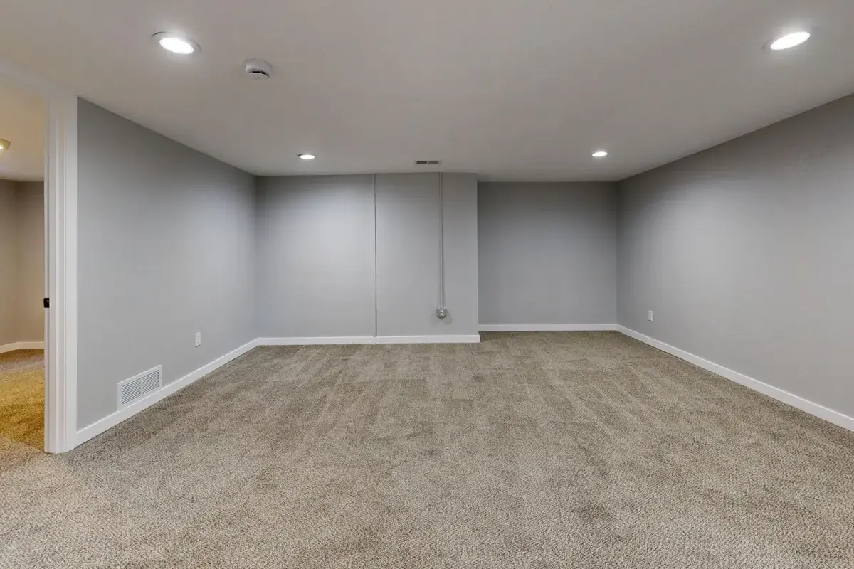 Example after: rebuilt basement with drywall, lighting and carpet